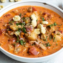 A white bowl filled with Manhattan clam chowder.