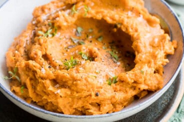 Mashed sweet potatoes in a gray bowl.