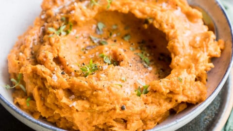 Mashed sweet potatoes in a gray bowl.