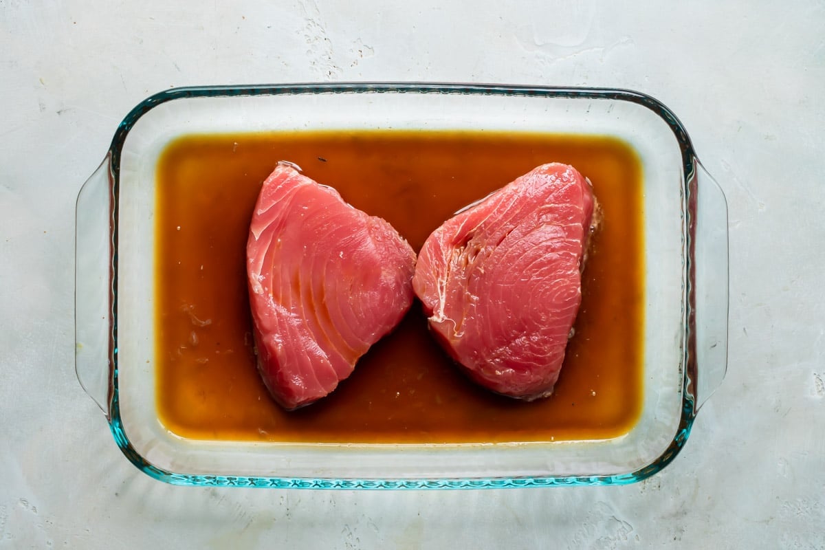 Ahi tuna in a clear baking dish before being cooked.