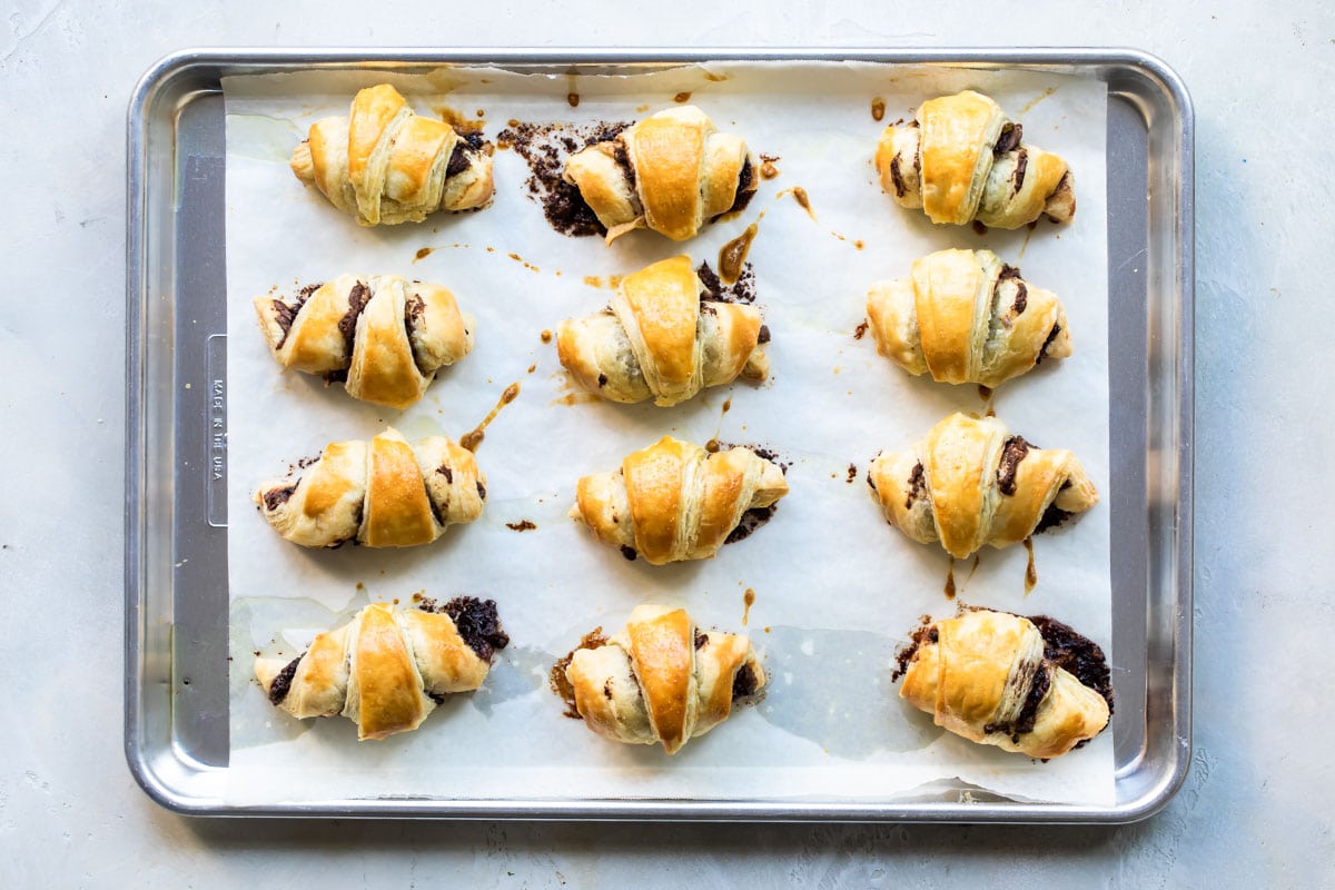 Baked banana nutella croissants on a parchment paper lined baking sheet.