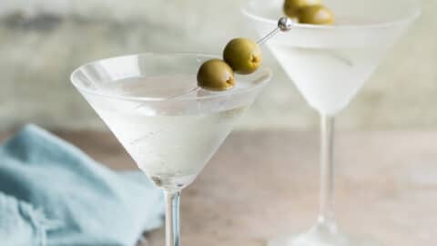 Two dry martinis garnished with green olives.