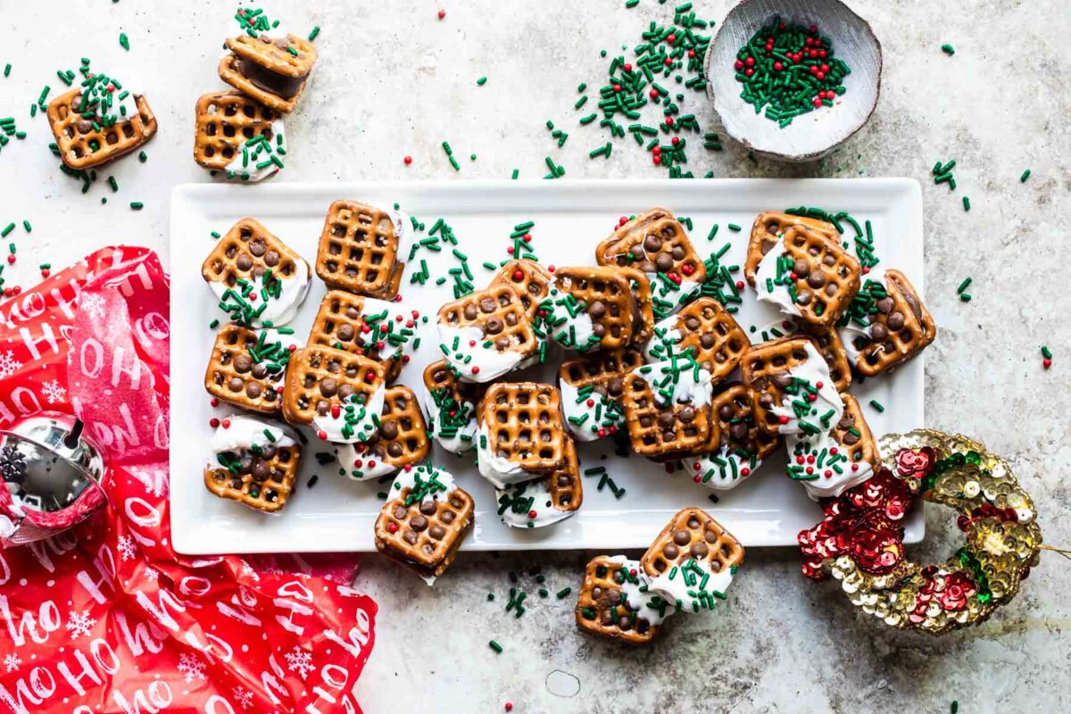 Rolo pretzel candies on a tray with Christmas sprinkles.