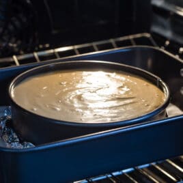 Water being poured into a pan to make a water bath for a cheesecake.