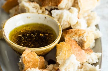 Bread Dipping oil in a small dish surrounded by bread pieces.