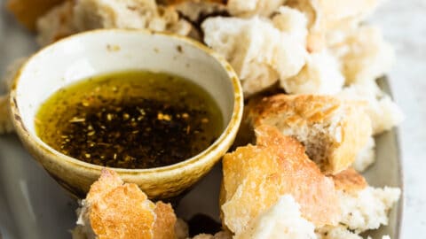 Bread Dipping oil in a small dish surrounded by bread pieces.