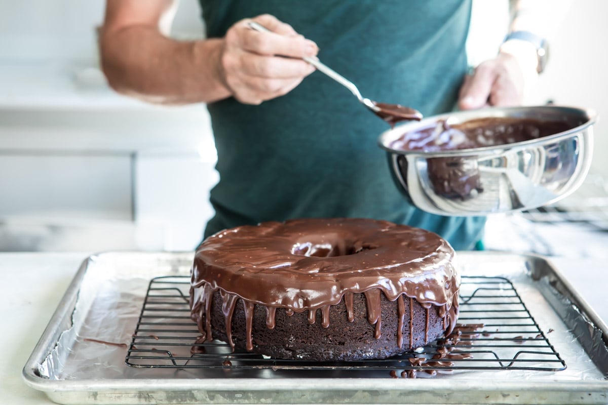 Someone pouring chocolate glaze over a ding dong cake.