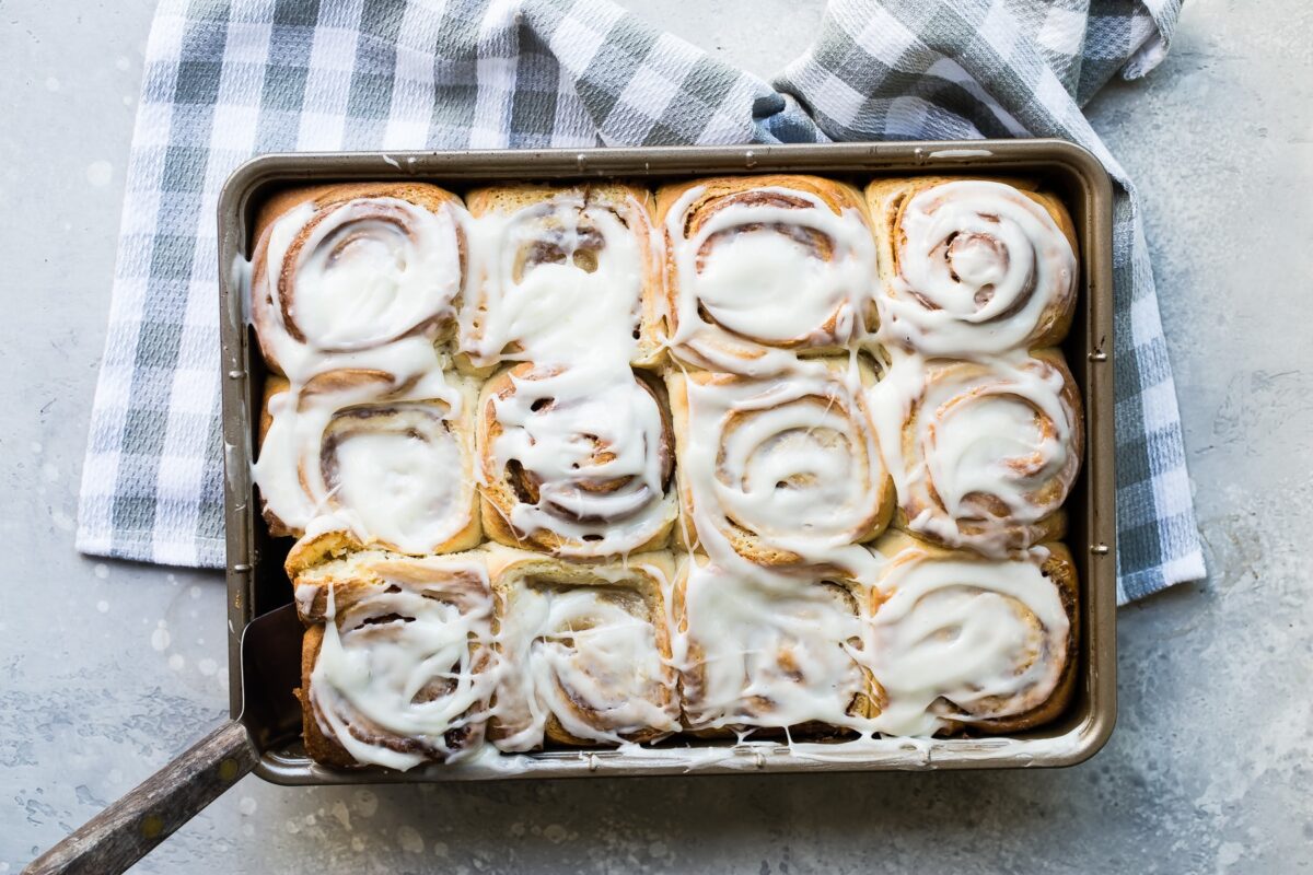 Cinnamon rolls after glazing in a pan.