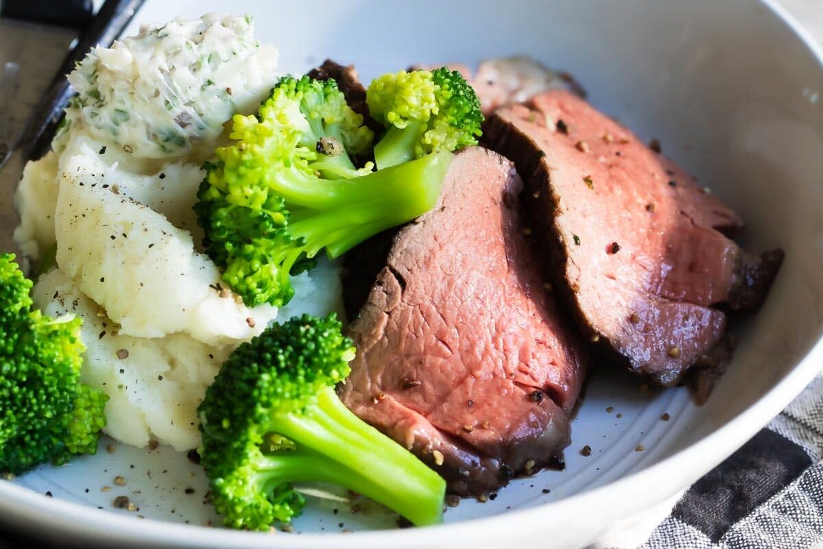 Beef tenderloin, broccoli and mashed potatoes in a bowl.