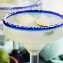 Two margaritas in blue-rimmed hand-blown Mexican margarita glasses.