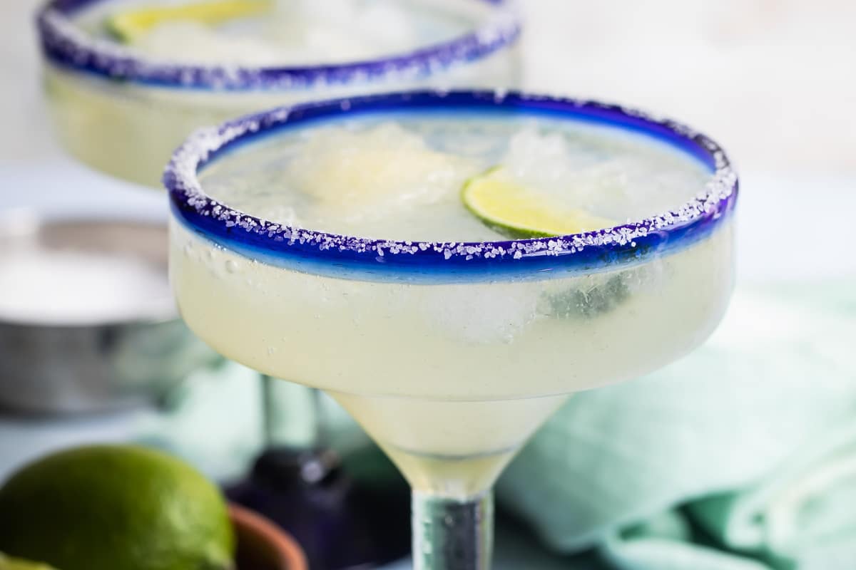 Two margaritas in blue-rimmed hand-blown Mexican margarita glasses.