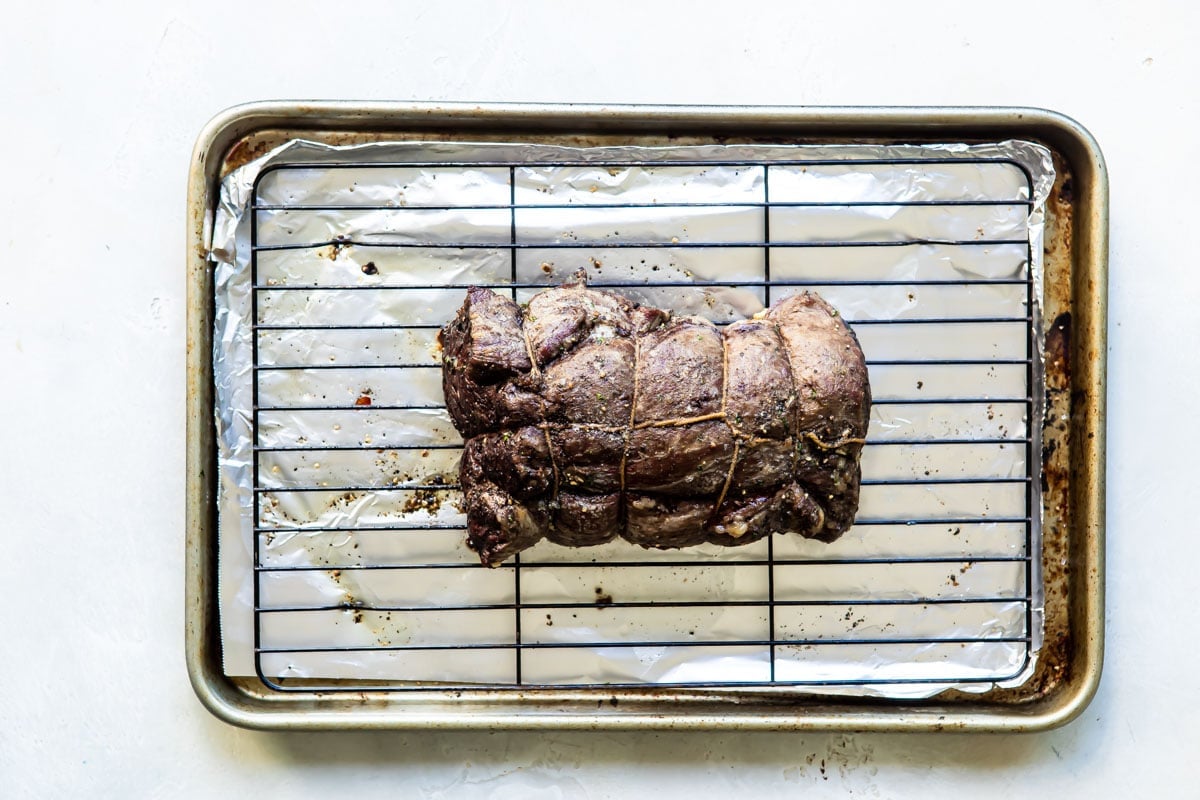 A roasted beef tenderloin on a rack.
