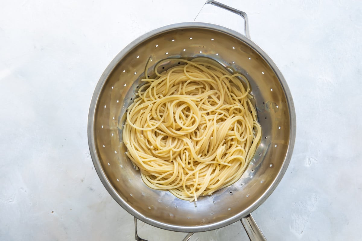 Spaghetti noodles in a colander.