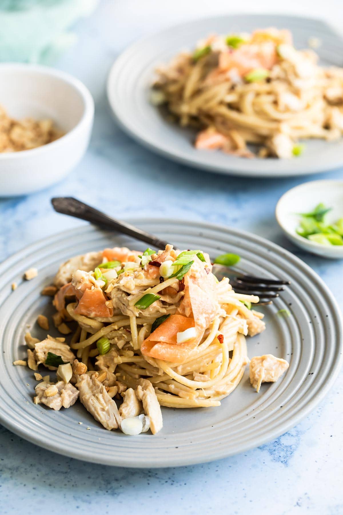 Thai peanut chicken noodles on a gray plate.