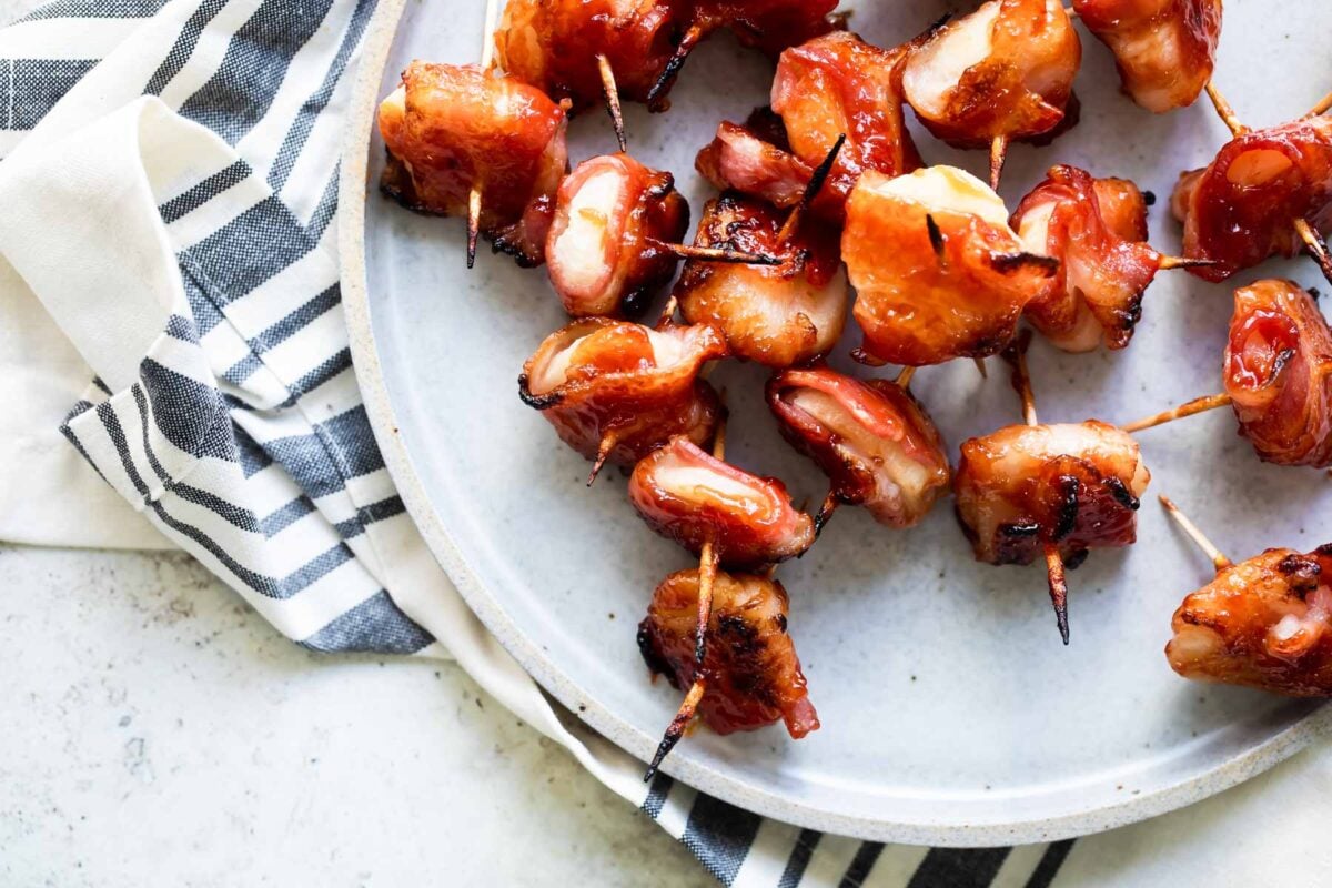 Bacon wrapped water chestnuts on a gray plate.
