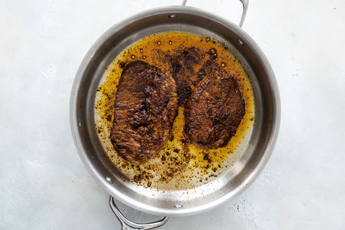 Cooking chipotle copycat steak in a skillet.