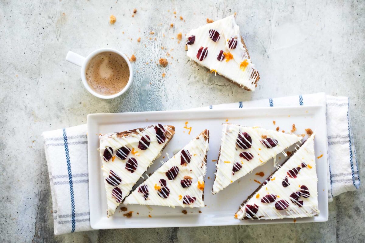Cranberry bliss bar triangles on a white platter.