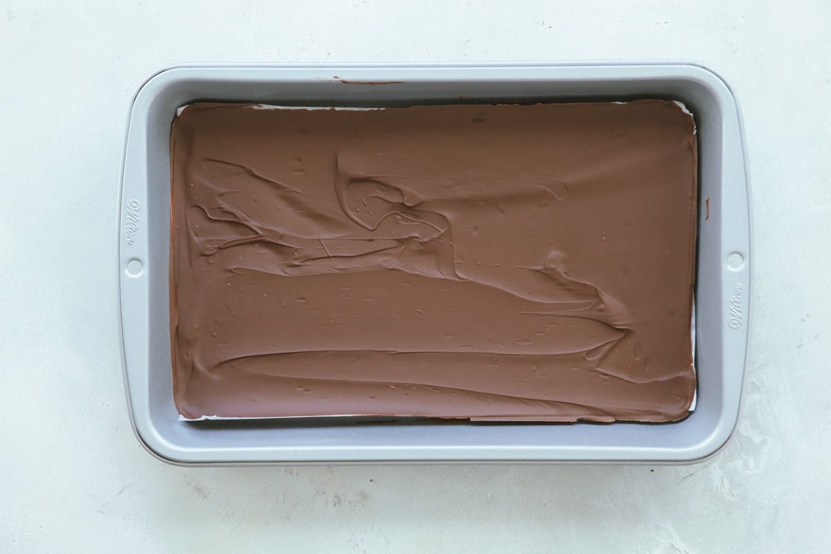 A layer of hardened chocolate spread out in a baking pan.