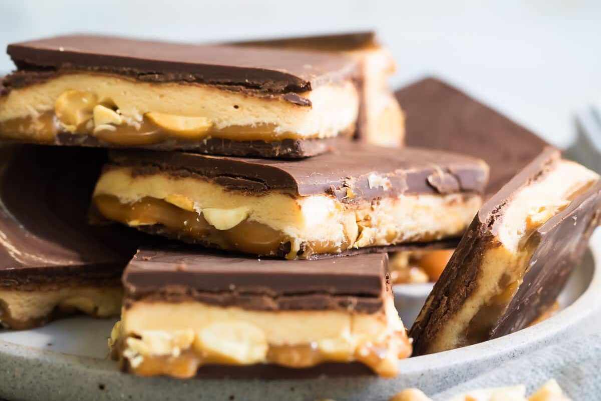 A stack of homemade Snickers bars on a small gray plate.