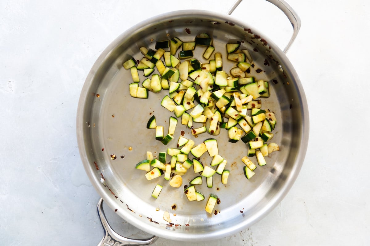 Zucchini cooking in a skillet.