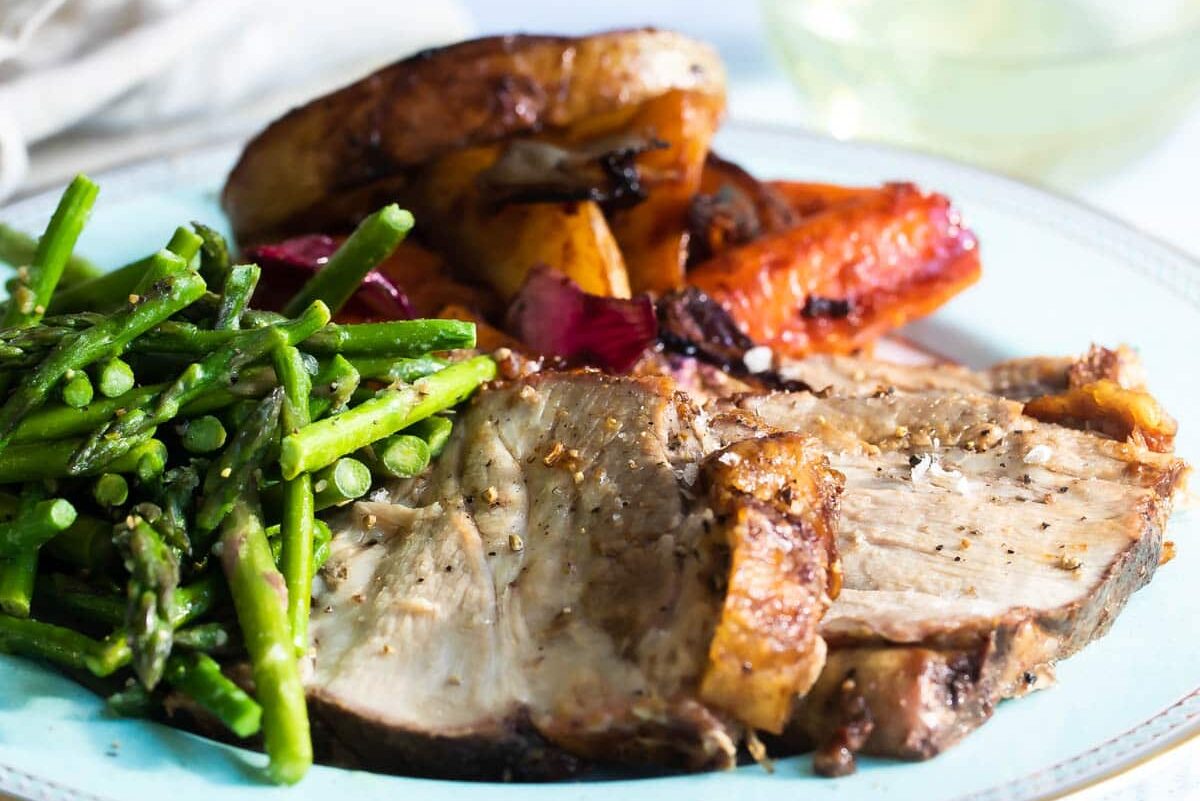 Pork roast, asparagus and vegetables on a plate.