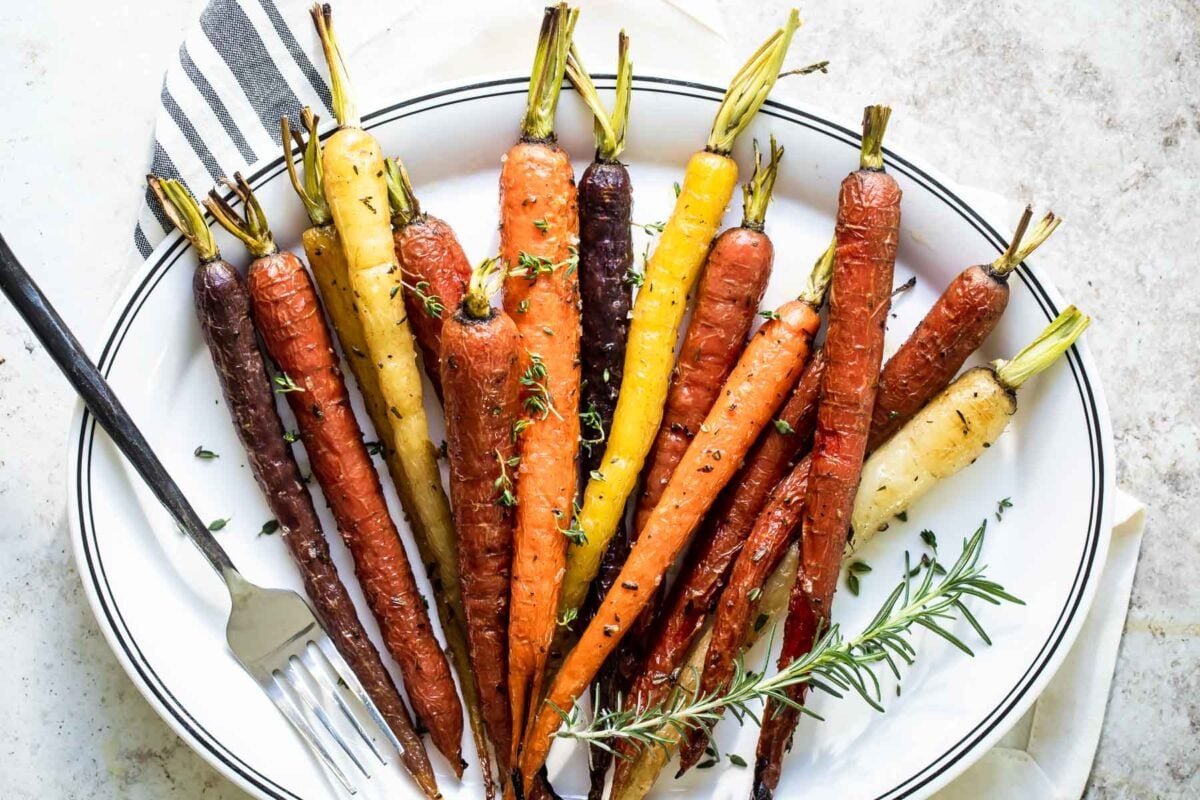Roasted carrots on a white oval platter.