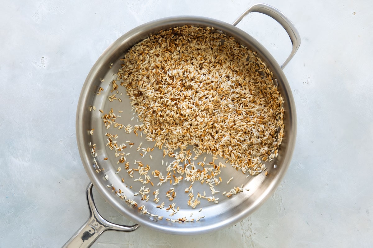 Rice being browned in a skillet.