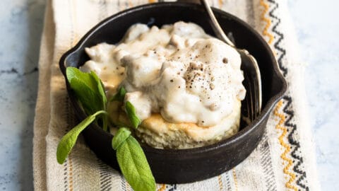 Biscuits and gravy in a small black skillet.