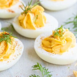 Deviled eggs on a round wooden platter.