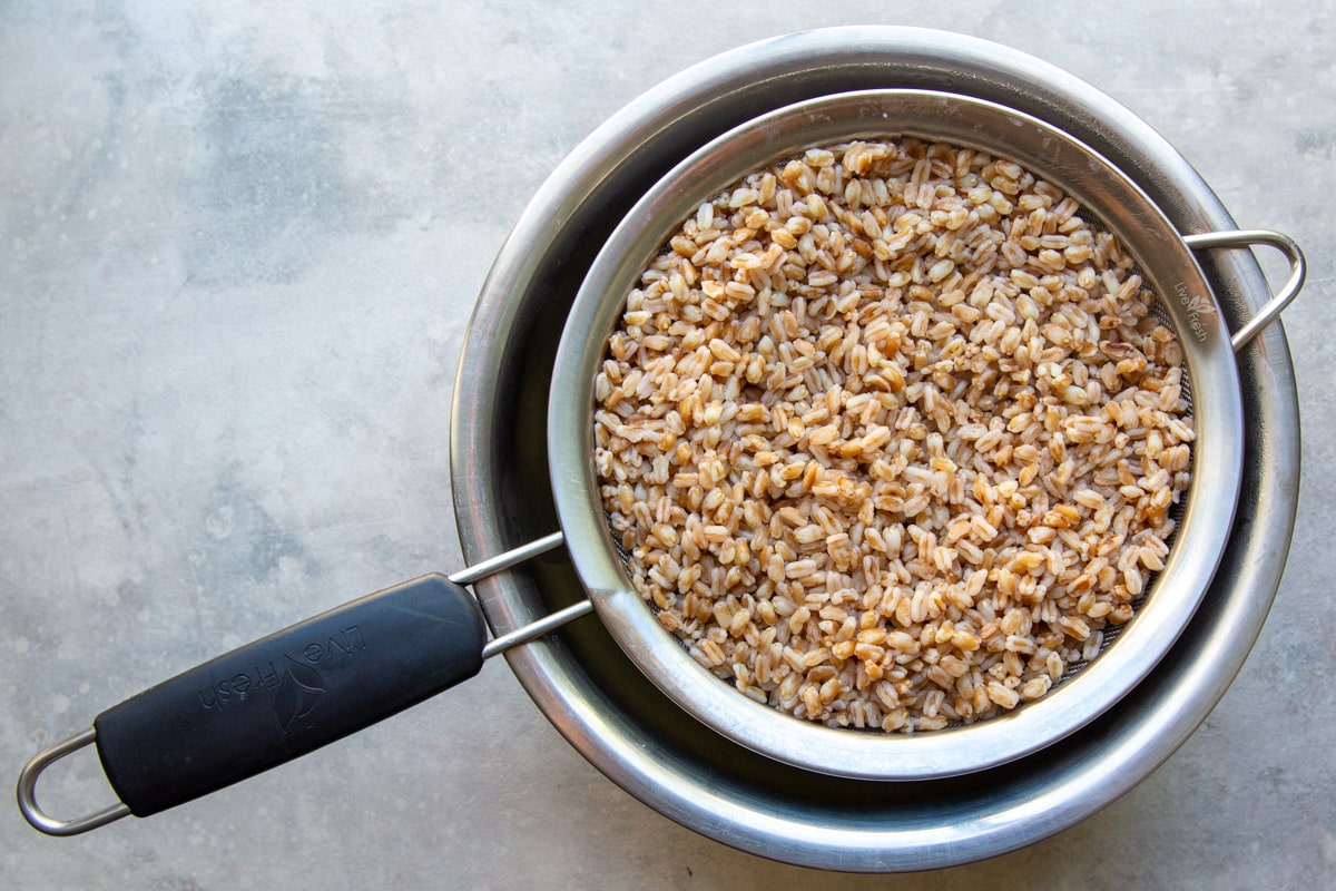 Draining farro after cooking.