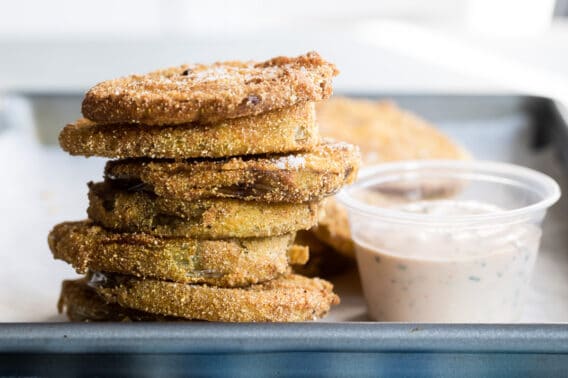 A stack of fried green tomatoes with a side of remoulade.