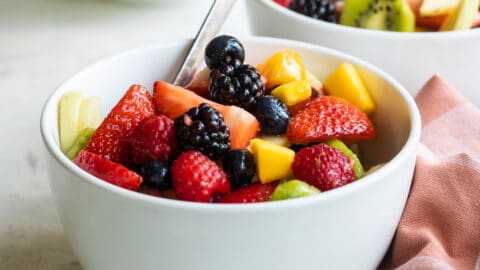 Fruit salad in a small white bowl.