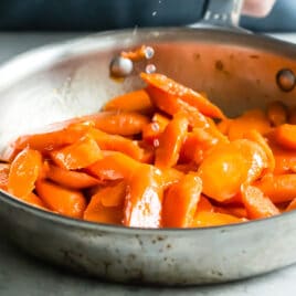 Glazed carrots in a silver skillet.