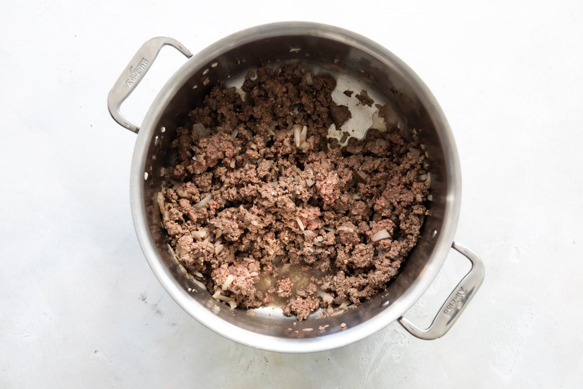 Ground beef and onion in a saucepan.