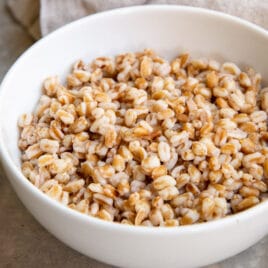 A white bowl with cooked farro in it.