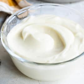 Homemade mayonnaise in a clear cup.