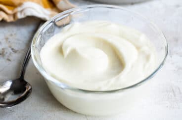 Homemade mayonnaise in a clear cup.
