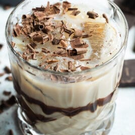 A mudslide cocktail with chocolate in the background.