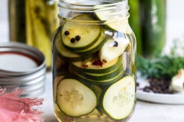 Three mason jars filled with pickles.