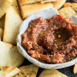 Roasted eggplant dip on a plate with triangles of bread.