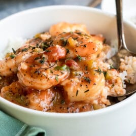 Shrimp Étouffée in a white bowl over rice.