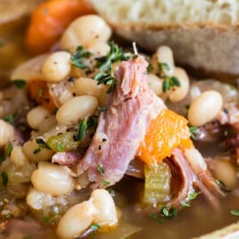Slow cooker ham and bean soup in a brown bowl.
