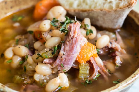 Slow cooker ham and bean soup in a brown bowl.