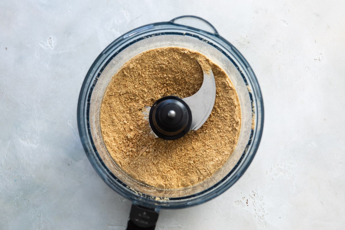 Crushed graham cracker crumbs in a food processor.