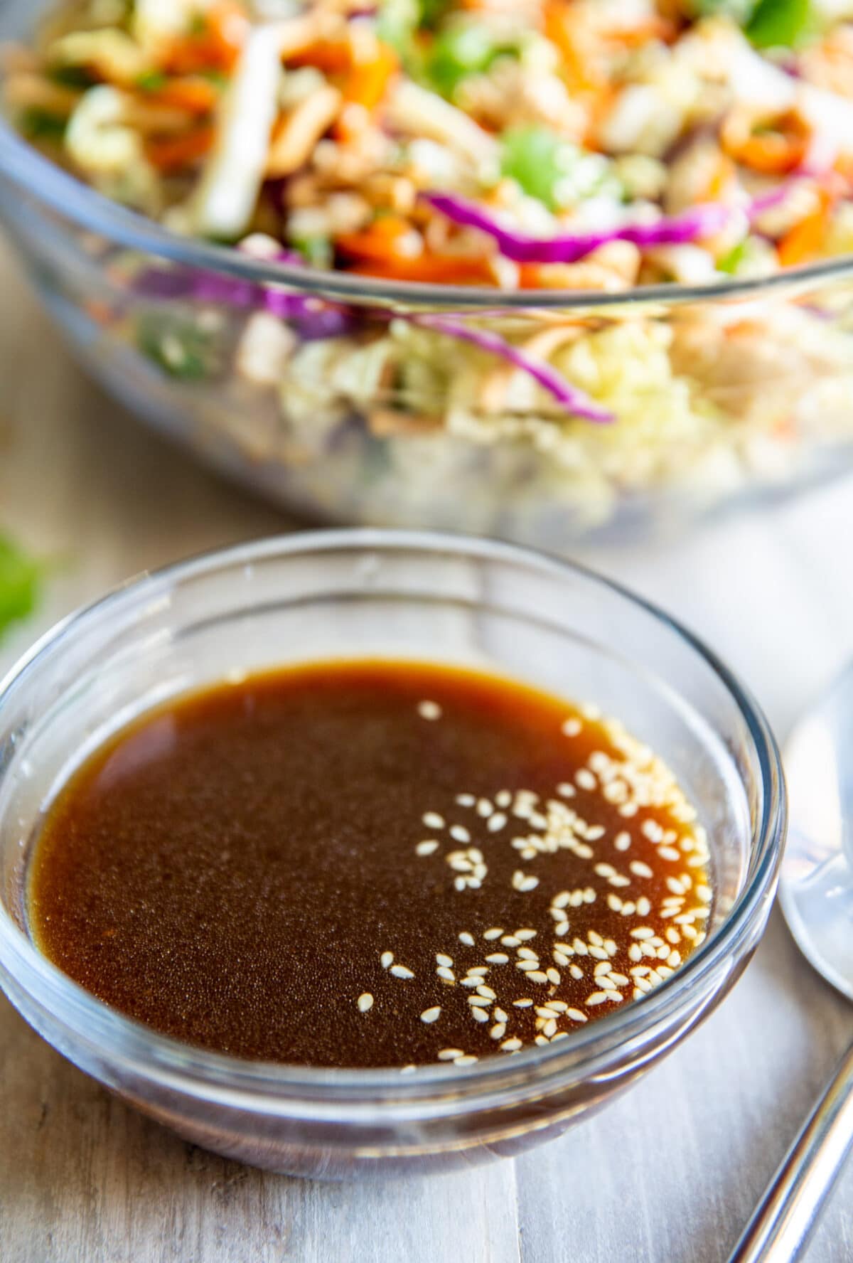 A bowl of Asian Salad Dressing sitting in front of a bowl of Chinese Chicken Salad.