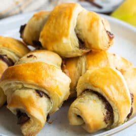 Baked banana nutella croissants on a white plate.