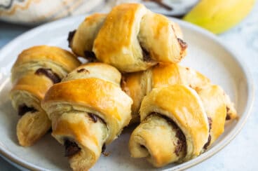 Baked banana nutella croissants on a white plate.