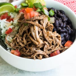 A bowl of Chipotle copycat Barbacoa beef with black beans, cilantro-lime rice, and pico de gallo salsa.