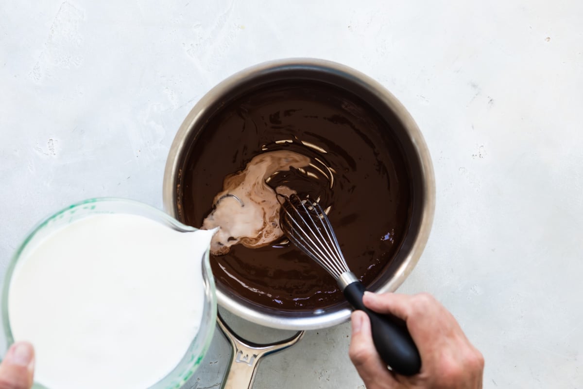 Milk being added to chocolate sauce mixture for hot chocolate.