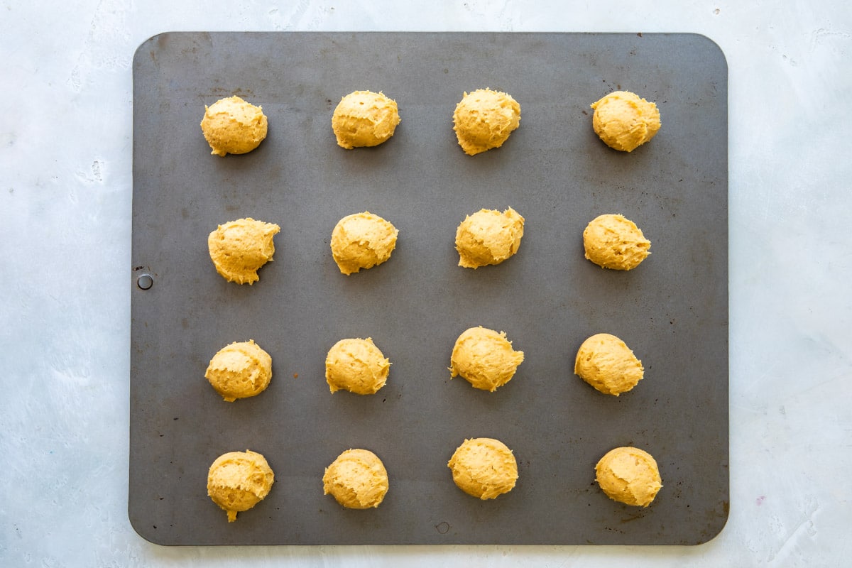 Pumpkin cookies on a baking sheet before being baked.